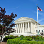 UNPRECEDENTED Apology Reveals Supreme Court Fracture…. Supreme Court building with American flag and trees.