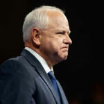 Elderly man in a suit looking determined.