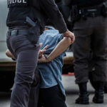 Police officer arresting and handcuffing a person.