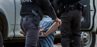 Police officer arresting and handcuffing a person.