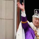 King Charles III in coronation attire waving.