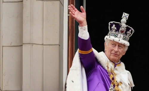 shutterstock_2338087303.jpg King Charles III in coronation attire waving.