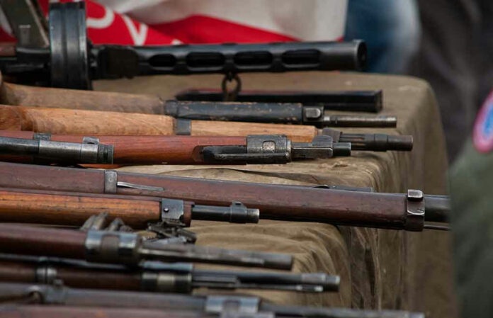 1914876166 Old rifles displayed on a table