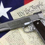 Handgun resting on historical document with American flag backdrop