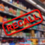 Recall text overlay on blurred store shelves background.