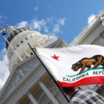 California state flag waving near a white domed capitol building