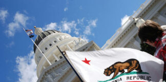 California state flag waving near a white domed capitol building