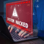 System Hacked warning on laptop screen.