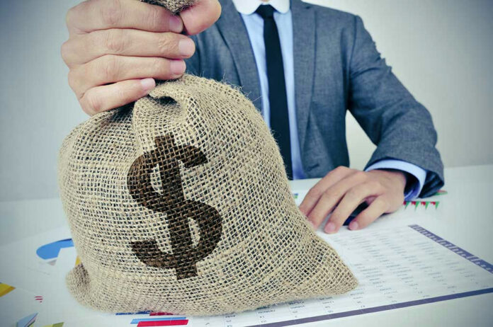 Person holding burlap bag with dollar sign.
