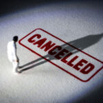miniature figure standing near a large cancelled stamp