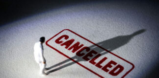 miniature figure standing near a large cancelled stamp