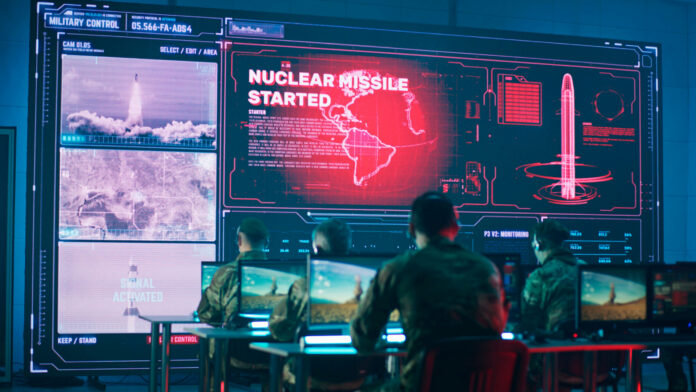 Military personnel monitor a command center screen showing missile launch alerts