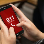 Person holding smartphone displaying emergency call screen