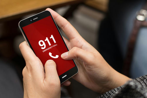 Person holding smartphone displaying emergency call screen
