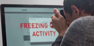 Person photographing computer screen with warning message