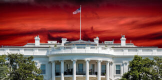 The White House with an American flag against a dramatic red sky