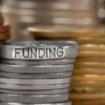 Stack of coins with the word funding engraved