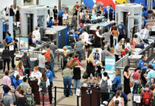 Crowd at an airport security checkpoint with TSA officers.