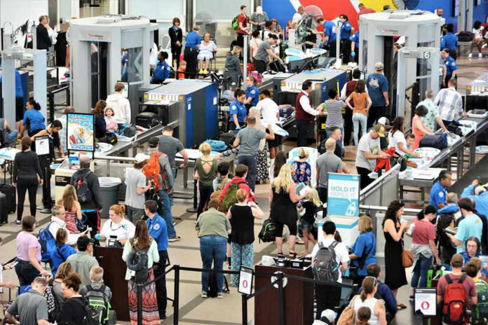 1463547893 Crowd at an airport security checkpoint with TSA officers.