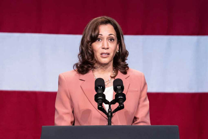 Woman speaking at podium with American flag background.