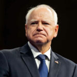 Man in suit with American flag pin.