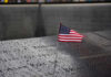 9/11 Families Revolt – Order Muslim Mayor To STAY AWAY American flag on a rainy memorial nameplate.