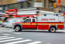 Woman BIRTHS Baby in the Middle of the Road! Red ambulance driving quickly through a city street.