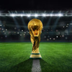 Golden trophy on soccer field under stadium lights