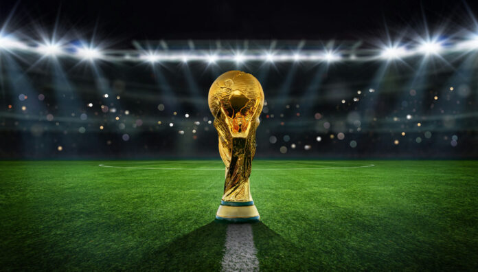 Golden trophy on soccer field under stadium lights