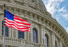 US flag waving in front of Capitol building.