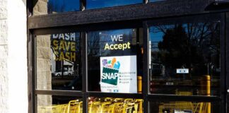 Store entrance with yellow shopping carts behind glass doors