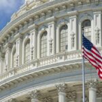 American flag before ornate neoclassical capitol building