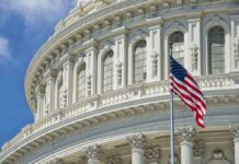 American flag before ornate neoclassical capitol building