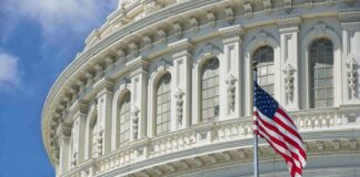 American flag before ornate neoclassical capitol building
