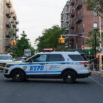 NYPD police SUV blocking a city street at a taped-off scene