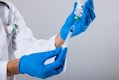 A healthcare professional preparing a syringe with a vaccine