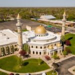 Lt. Governor Targets Mosques — First Amendment Showdown Aerial view of a mosque with golden domes and minarets surrounded by greenery