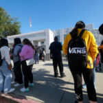Students standing outside a high school entrance