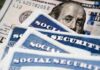 Government Sleepwalks Toward 22% Social Security Cut Social security cards and a hundred dollar bill arranged together