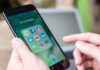 Person holding smartphone with social media app folder open