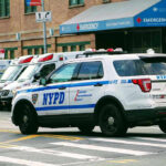 Police car and ambulances outside emergency room entrance.