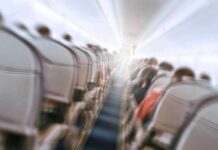 Airplane cabin aisle with blurred passengers and seats