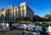 Synagogue exterior with memorial flowers and star-shaped tributes on lawn