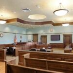 Mom SHOOTS Baby in the Face – Says “It Was Worth It” Empty courtroom with wooden benches and judge's bench