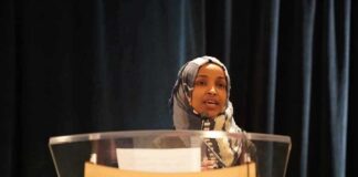 Woman in hijab speaking at a podium