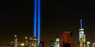 New York City skyline at night with twin blue light beams