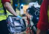 Paramedic with defibrillator beside patient on stretcher