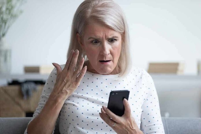 Older woman looking shocked at a smartphone