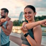 Dems Rob Female Athletes – 2,300 Medals DISAPPEAR Woman stretching her arm outdoors with man in background