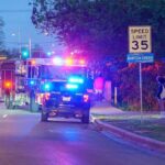 Emergency vehicles with flashing lights on a city street at night